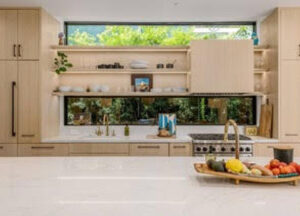 Modern kitchen with light wood cabinets and a scenic window view.