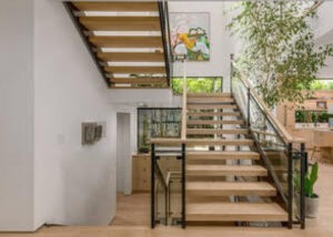 Modern wooden staircase with metal railing in a bright, minimalist home.