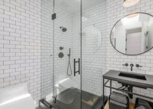 Modern bathroom with glass shower enclosure and white subway tiles.