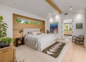 Modern bedroom with wooden accents and a large window.